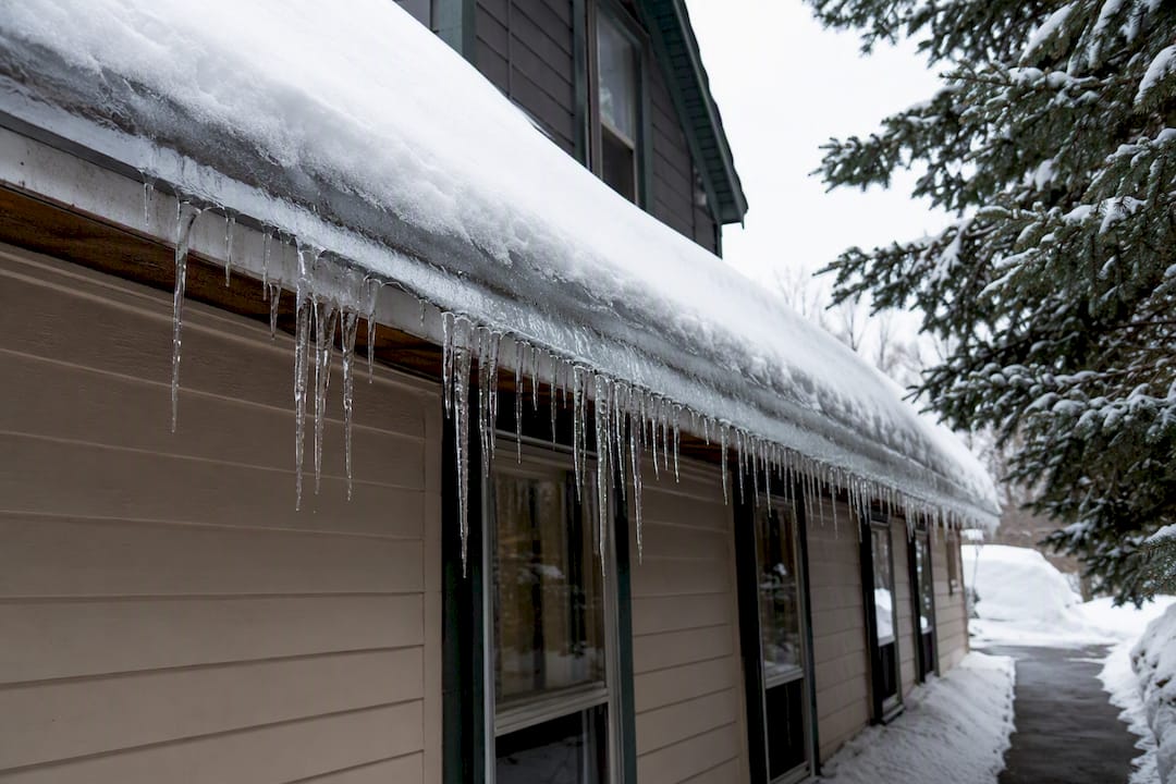 Ice dam along a snowy Maine roofline