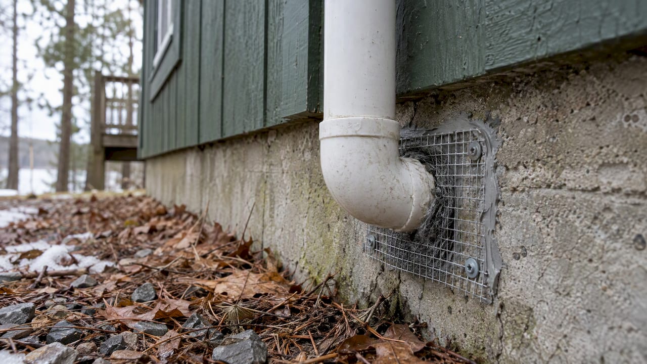 Hardware cloth seals a pipe opening at a camp foundation